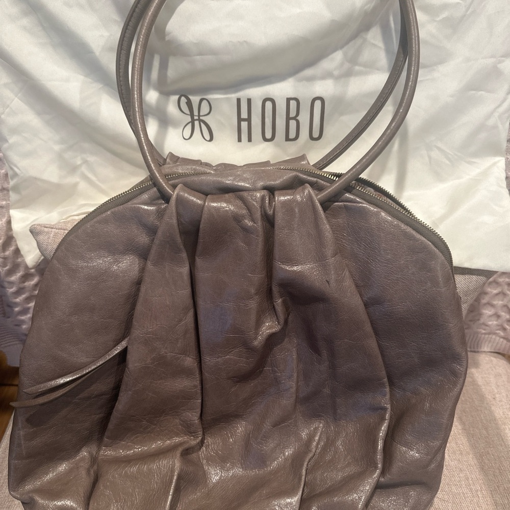 HOBO taupe/mocha shoulder bag with brass hardware and exterior pocket.